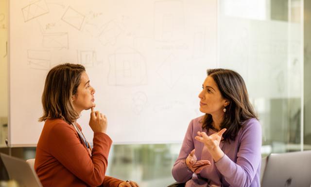 Fundadoras conversando junto a una pizarra de estrategia en una oficina de startups de Madrid
